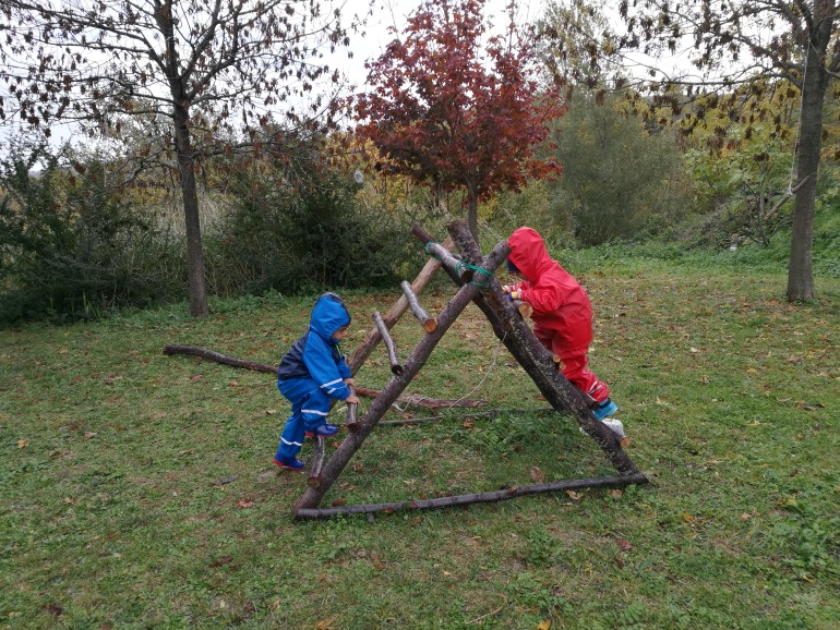 I bambini giocano con le strutture che hanno costruito con rami e corde