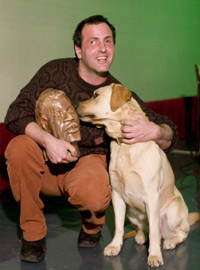 Felice Tagliaferri, in compagnia del cane Tobia, tiene in mano una delle sue sculture