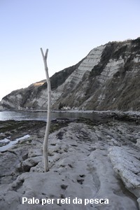 Un palo per reti da pesca  nei buchi fatti nella roccia