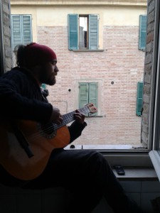 Manuel Lorenzetti mentre suona per i passanti dalla finestra di casa in via Raffaello